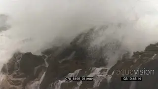 Big waves rolling in over rocks Overcast rain conditions