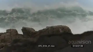 Big waves rolling in over rocks Overcast rain conditions