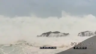 Big waves rolling in over rocks Overcast conditions