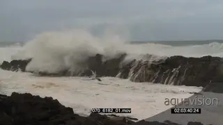 Big waves rolling in over rocks Overcast rain conditions
