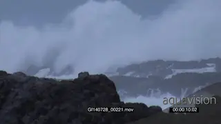 Big waves rolling in over rocks Overcast rain conditions