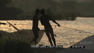 Local young men pulling out fishing nets from river