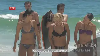 Surfers 2 carrying surf boards and 3 model ladies in bikini's exiting water walking out.