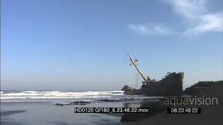 Shipwreck on beachfront pan across to ocean view