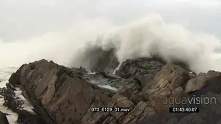 Big waves rolling in over rocks Overcast conditions