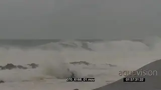 Big waves rolling in over rocks Overcast rain conditions