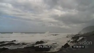 Big waves rolling in over rocks Overcast Storm clouds forming