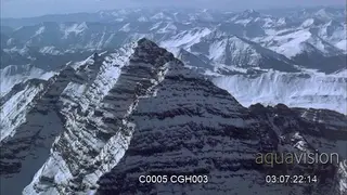 Aerial panning shot of rugged mountains.