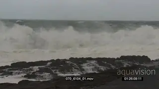 Big waves rolling in over rocks Overcast rain conditions