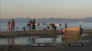 Local children playing bathing themselves in river canoes aligned in BG