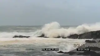 Big waves rolling in over rocks Overcast conditions