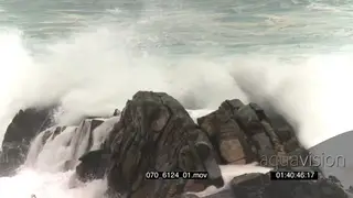 Big waves rolling in over rocks Overcast rain conditions