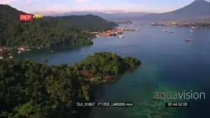 An aerial wide shot from the Port of Bitung harbour in Manado at sunrise to Lembeh…