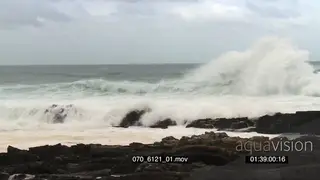 Big waves rolling in over rocks Overcast rain conditions