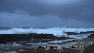 Big waves rolling in over rocks Overcast Storm clouds