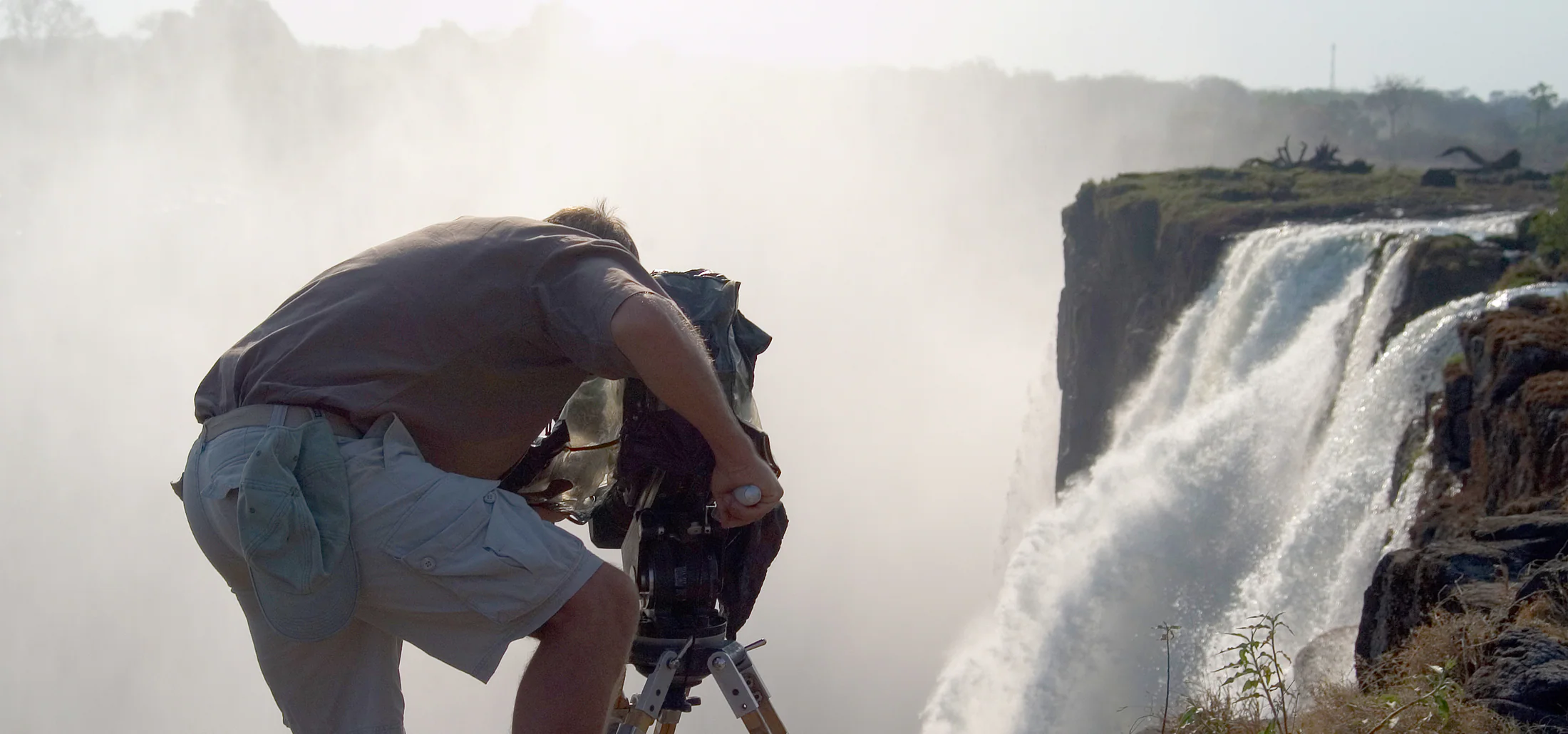 Camera operator filming on location at Victoria Falls