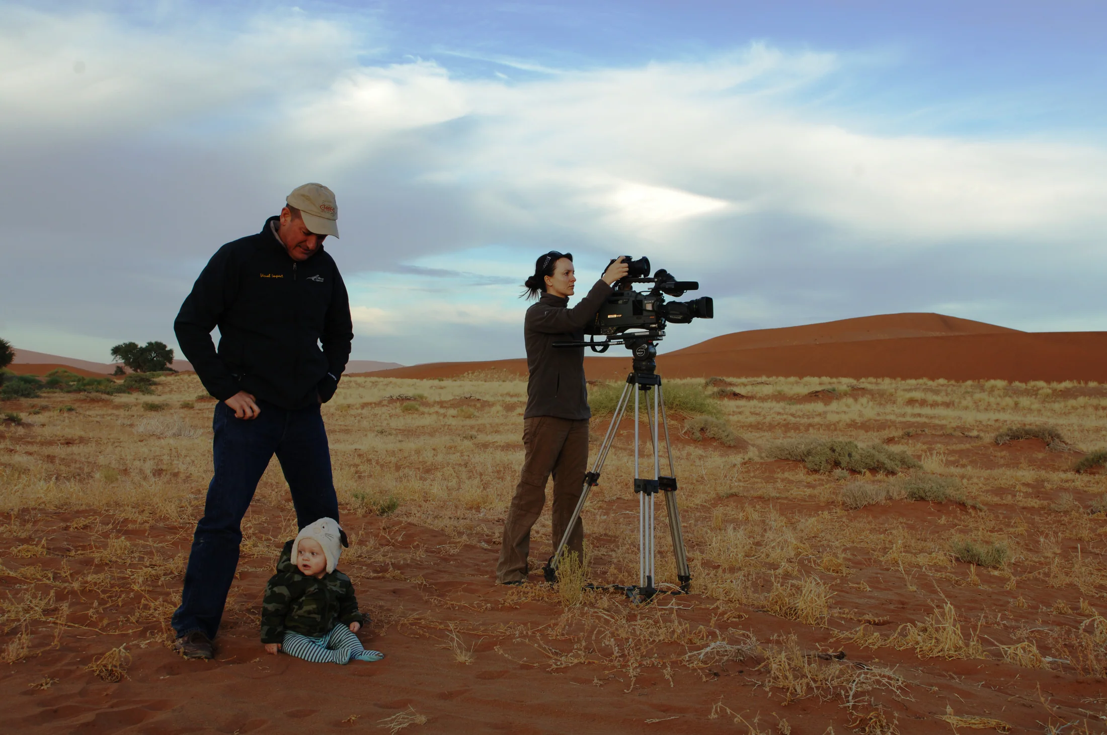 Small film crew setting up a camera among the Namib dunes