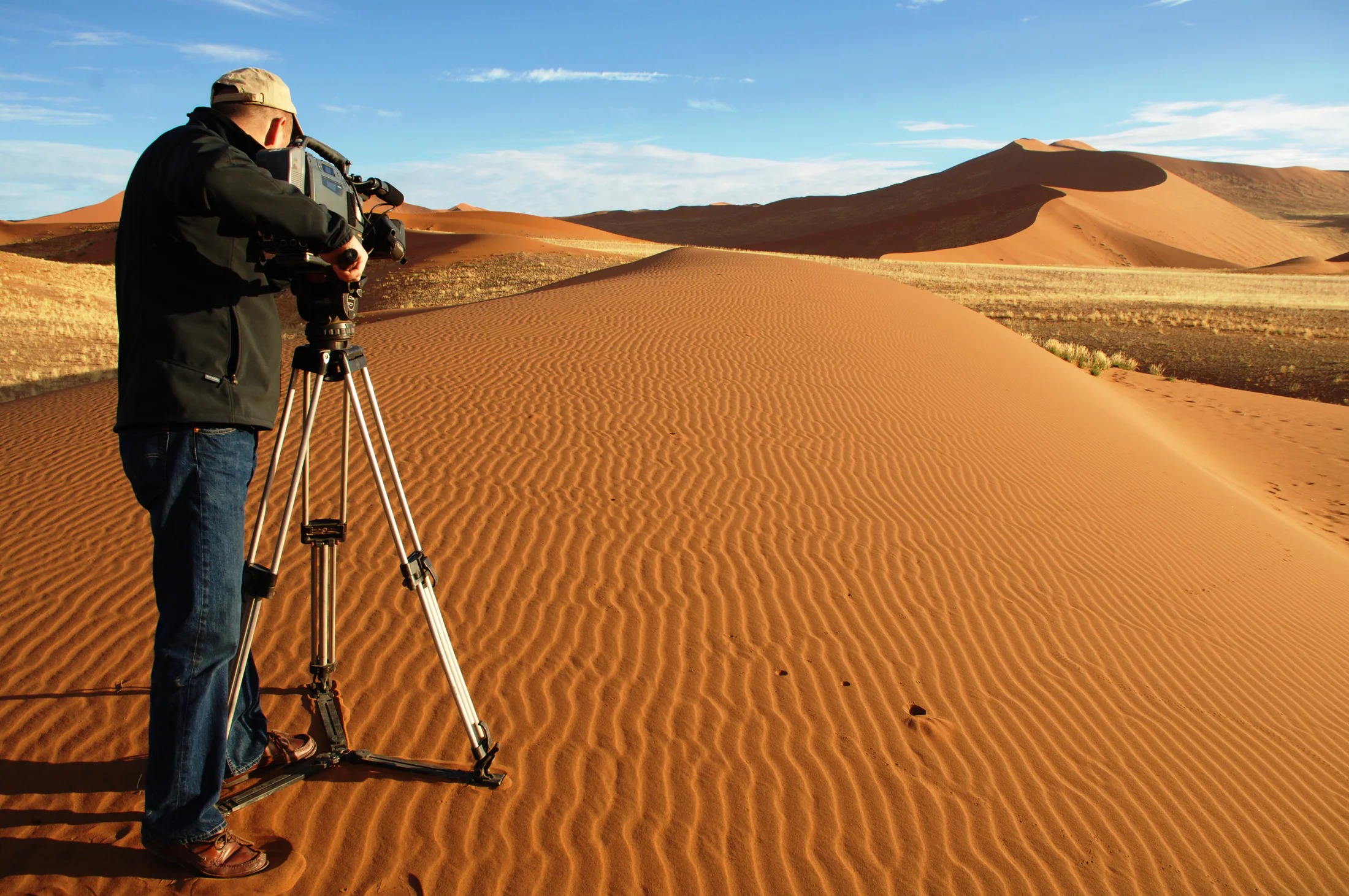 Camera operator filming on a Namib dune ridge